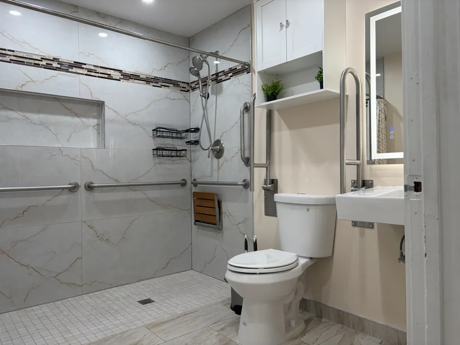A roll-in shower with no step, a fold-down seat and grab bars