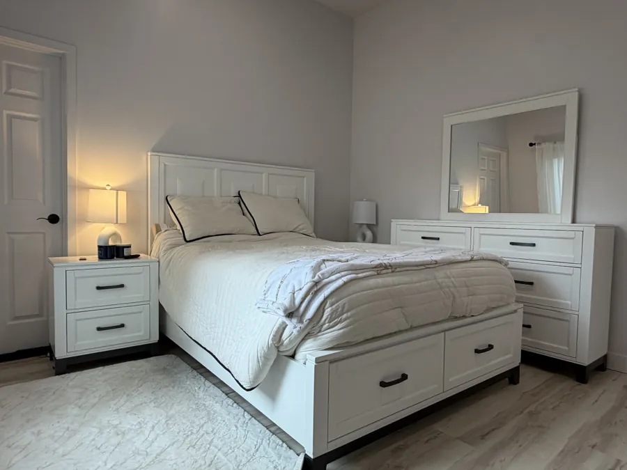 A private bedroom with a queen bed, matching dresser and bedside lamps