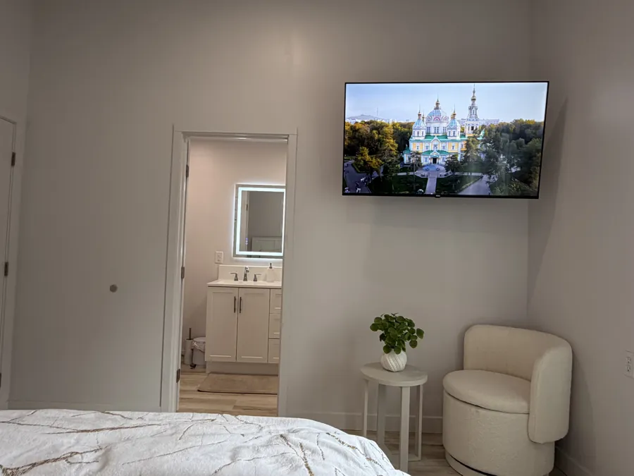 A private room with a TV, an armchair and its own bathroom