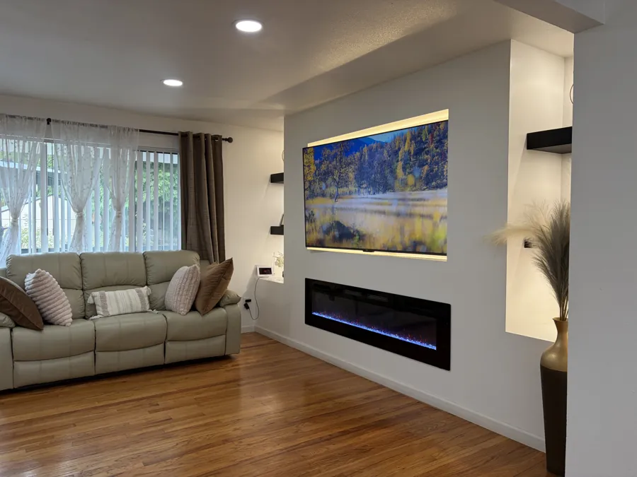 A large sofa in the living room facing the fireplace, with daylight through the curtains