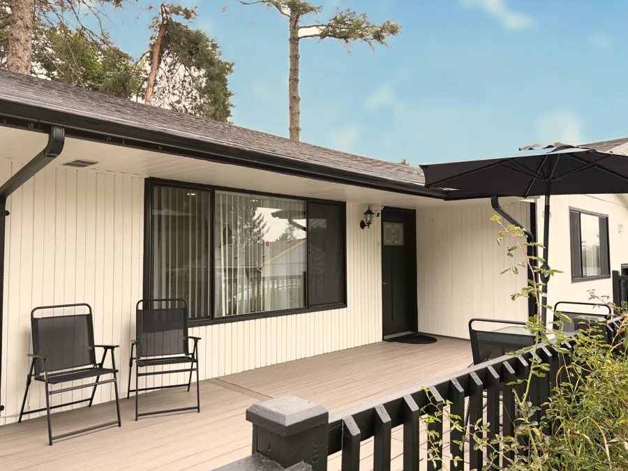 A covered porch with chairs beside the front door