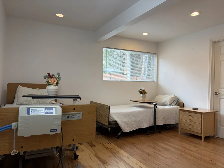 A bedroom at Number One Choice AFH with two hospital beds and a pressure-relief air mattress